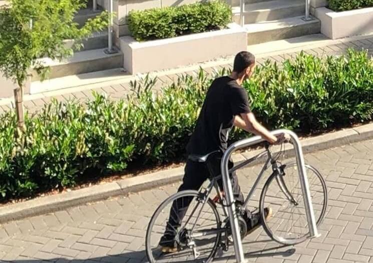 Bike thief walking with stolen bike and bike rack