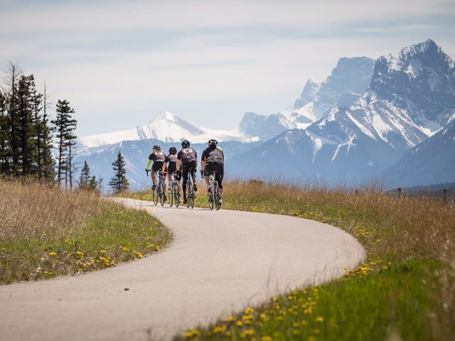 Group of cyclists riding on Legacy Trail into Banff National Park